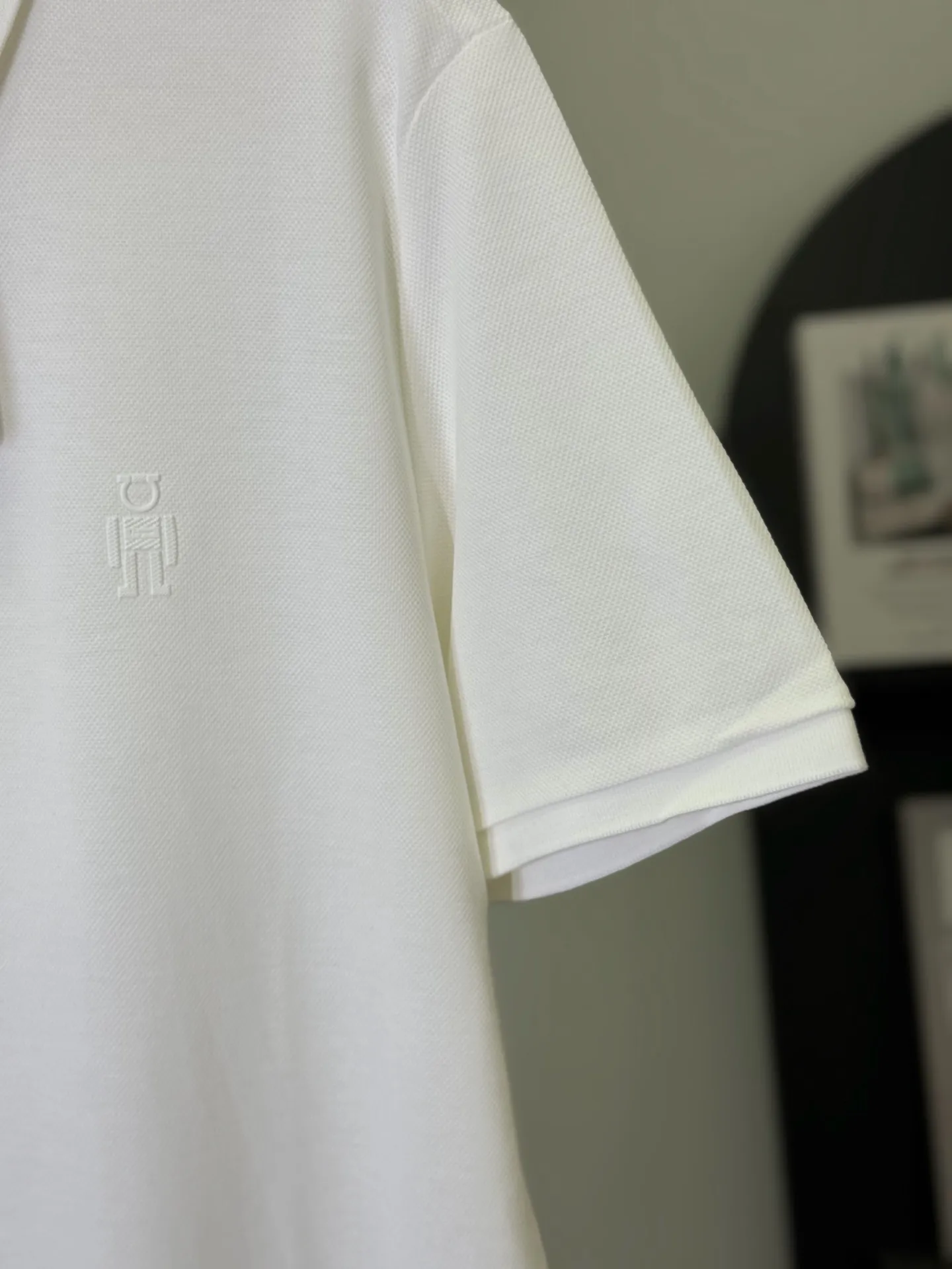 💋 Ferragamo white-bottom thin robot logo Polo shirt puts Italian elegance and avant-garde fun into this refreshing white Polo. The low-key robot logo of the same color on the chest, paired with exquisite brand buttons, is not too revealing on a pure white background, but can be recognized by knowledgeable people at a glance. It is a tasteful choice for mature men. We select high-count mercerized pearl cotton, which is draped and wrinkle-resistant, and has a neat and loose feeling on the upper body. It has a slightly loose fit and is not picky about your body shape. It can be easily held in business commuting and light formal occasions. A white Polo can keep you fresh and decent in all spring and summer occasions. M-3XL